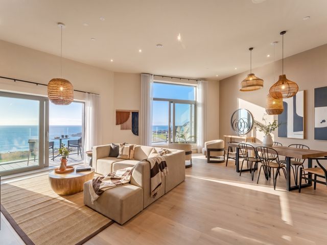 A living room with a sofa and dining table at Hidden 9 – Grand Bay Suite Hot Tub St Ive