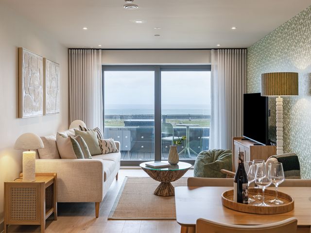 A living room with a sofa and a view of the sea at tbc in St. Ives