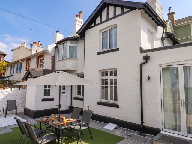 An outdoor dining area with table and chairs at Kents Cottage in Torquay