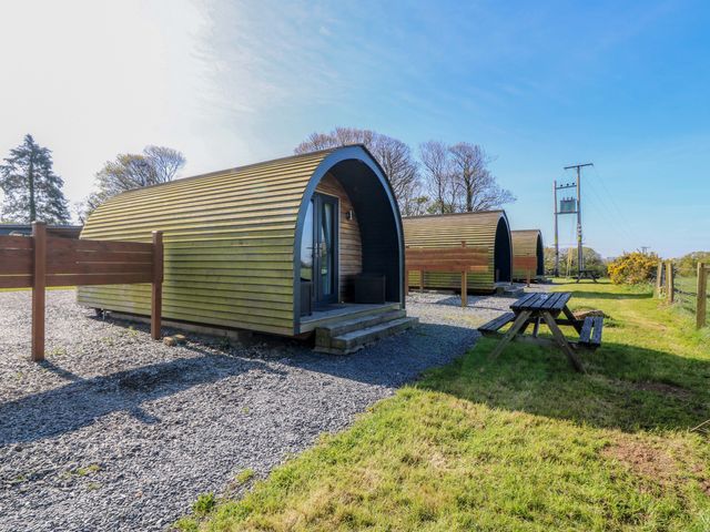 A view of wooden cabins with picnic table at Bron Eifion Pod 1 in Criccieth