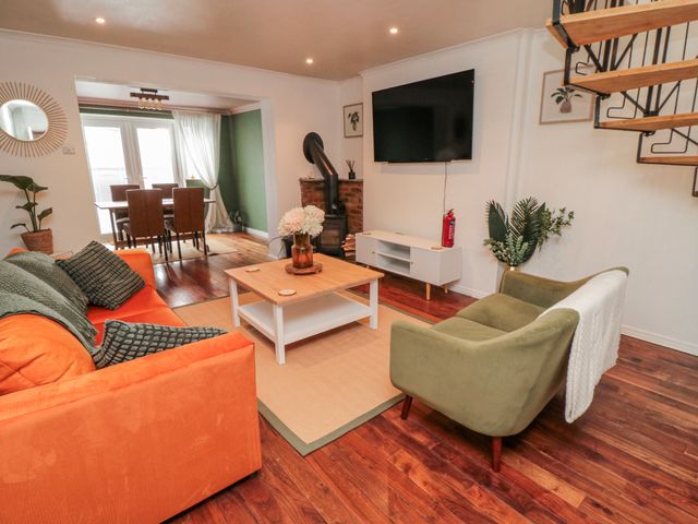 A living room with a sofa and a dining area at 3 Beck Mews in Scarborough