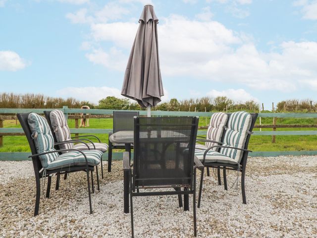 An outdoor seating area with a table and chairs at Likely Sunset in St. Austell