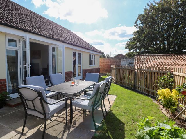 A garden with patio furniture at The Mill House Gardens Oulton Broad