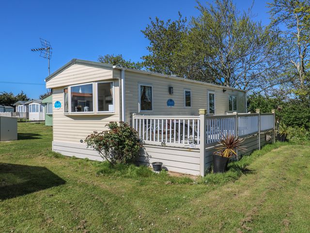 A caravan with decking and outdoor furniture at Valley Farm Number 448