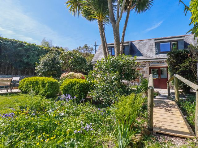 A garden with paths and plants at Camelia Cottage in St. Austell