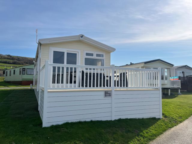 A caravan with a decking area at 26 Ocean View in Llwyngwril