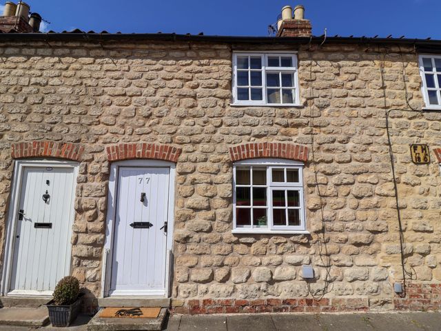 A stone cottage with white doors and windows at The Cook’s Cottage in Malton