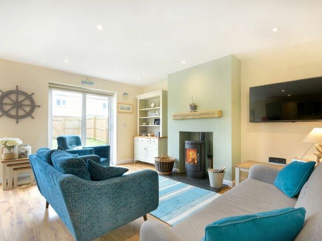 A living room with furniture and a fireplace at Beach Walk in Chathill