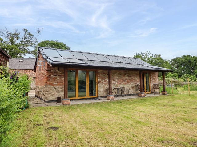 An outdoor area of a house with chairs and a table at Henlle Home Farm in Gobowen