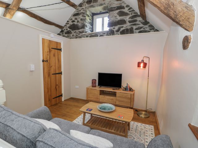 A snug with a sofa and television at Beudy Bach in Llanbedr
