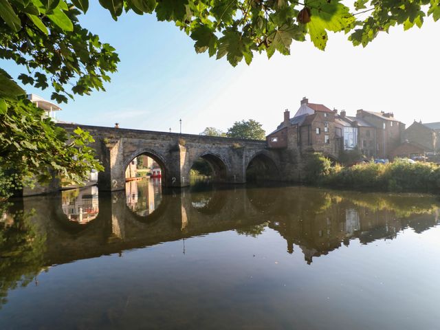 A bridge over water with houses on the bank at 22 Prospect Terrace in Brancepeth