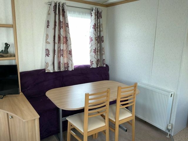 A dining area with a sofa and table at St Monans Holiday Park - Holiday Accommodation 19927 Anstruther