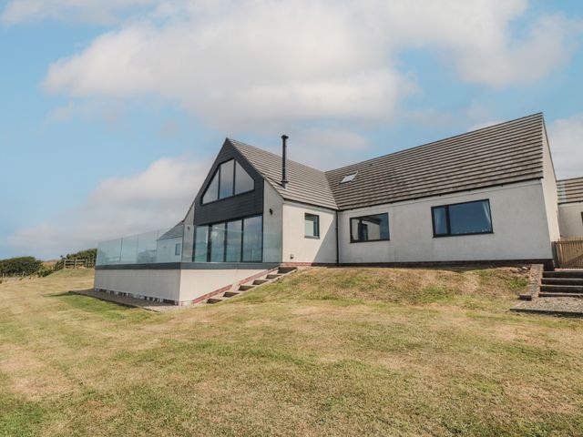 A house with a glass railing and lawn at Bay View