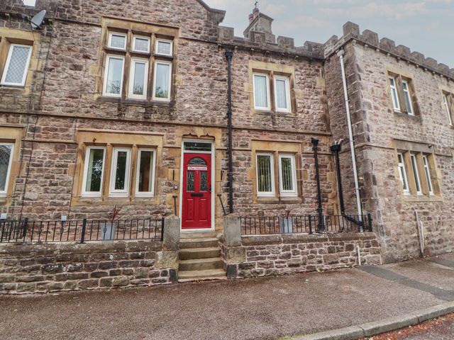 A building facade with a red door and windows at The Haven in Heysham