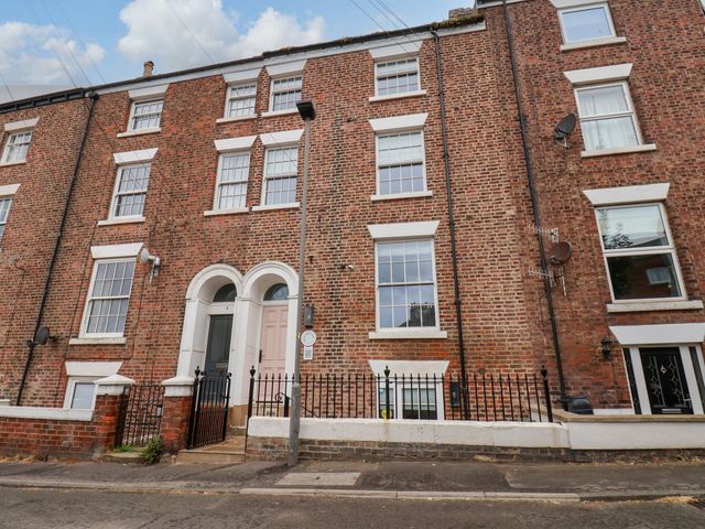A facade of a brick building with windows and a door at Apartment Pink in Whitby