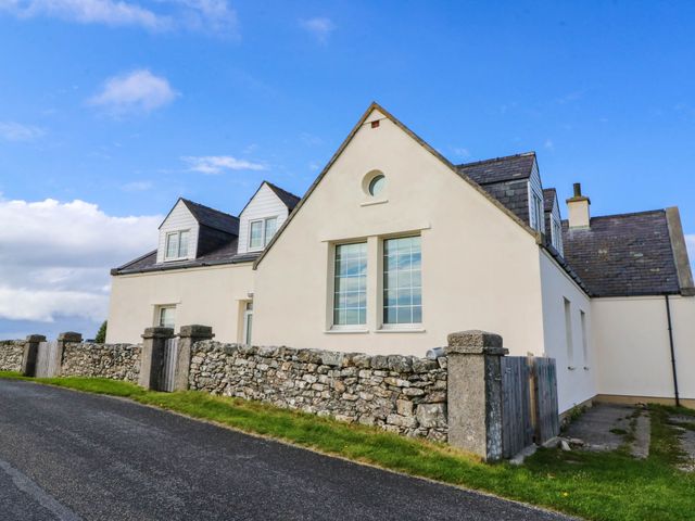 A house with stone wall and windows at Old School House Isle Of South Uist