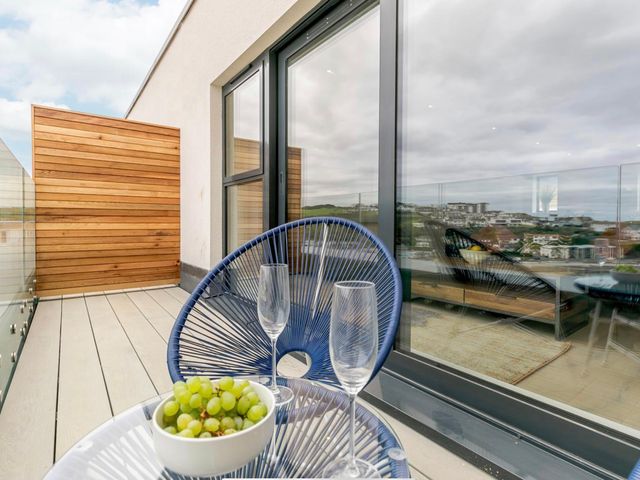 A balcony with a table and glasses at Seascape in Newquay