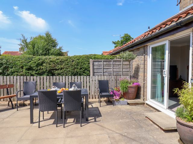 An outdoor patio area with a table and chairs at Wheeldale Cottage in Goathland
