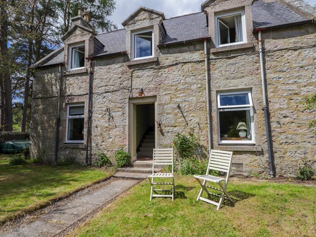 A house with two chairs and a pathway at Gairnshiel School House near Ballater