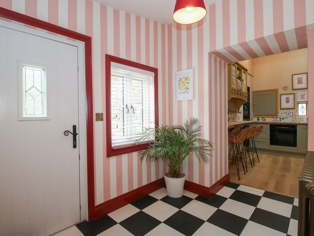 A hallway with a door and potted plant at The Dinky Dairy Treflach near Trefonen