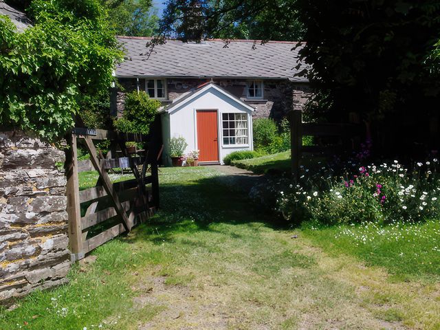 A garden with a path leading to a house at Whitefield Cottage in Brayford near North Molton
