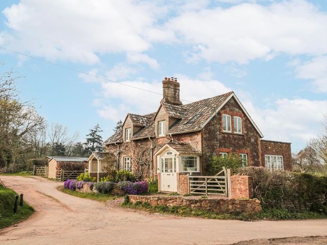 A house with a pathway and flowers at Tuxwell Lodge in Bridgwater