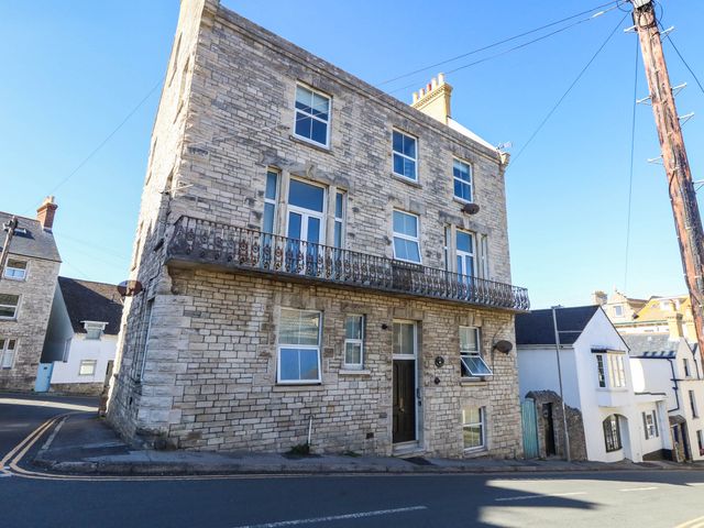 A corner building with a balcony and windows at Flat 3, 4 Park Road Swanage