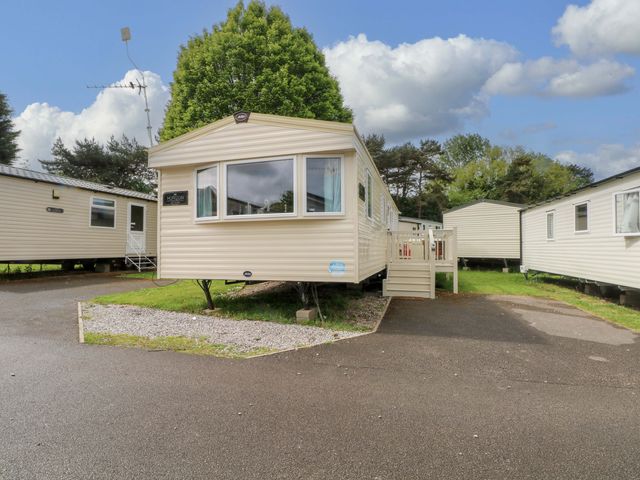 A caravan with a deck in front at Kensington 49