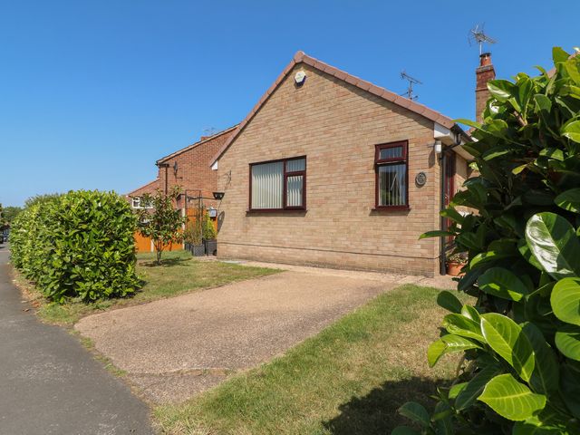 A house with a driveway and bush in front at 27a Wolds Drive Nottingham