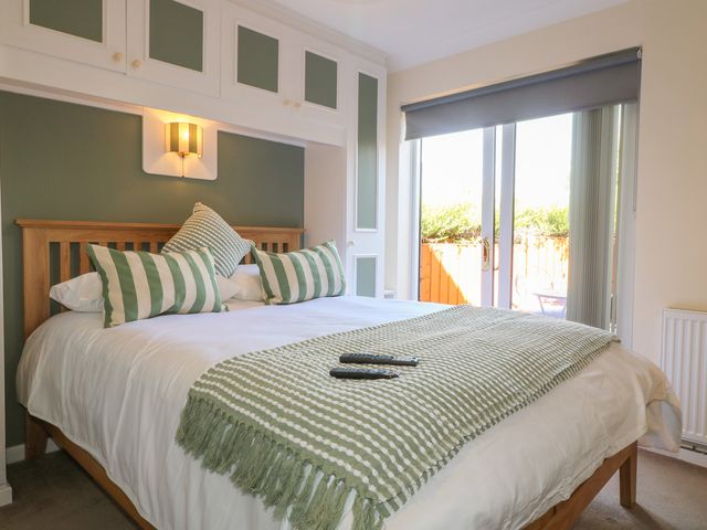 A bedroom with a bed and windows at 27a Wolds Drive Nottingham
