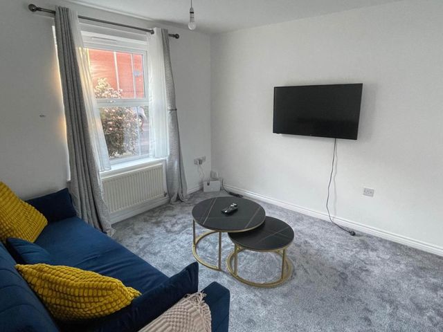 A living room with a sofa and coffee table at House Sleeps 5 with Garden and Parking