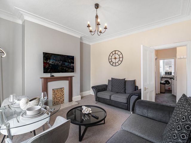 A living room with a television and dining table at Central Aberdeen flat Holburn St workspace parking in Aberdeen