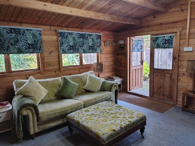 A living room with a sofa and ottoman at Forest Cabin Retreat-Sleeps 2-Garden, Wifi, Trails Alderholt