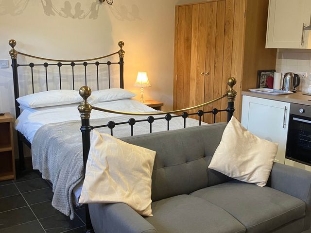 A bedroom with a bed and sofa at Cottage in Nuneaton - Sleeps 2 - Parking - Garden, Higham-on-the-Hill near Nuneaton
