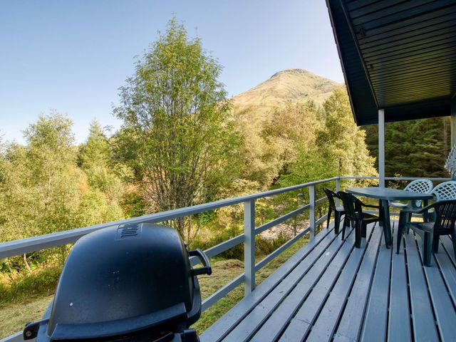 An outdoor space with a table and chairs at a 2 bedroom lodge with stunning loch, mountain views Crianlarich