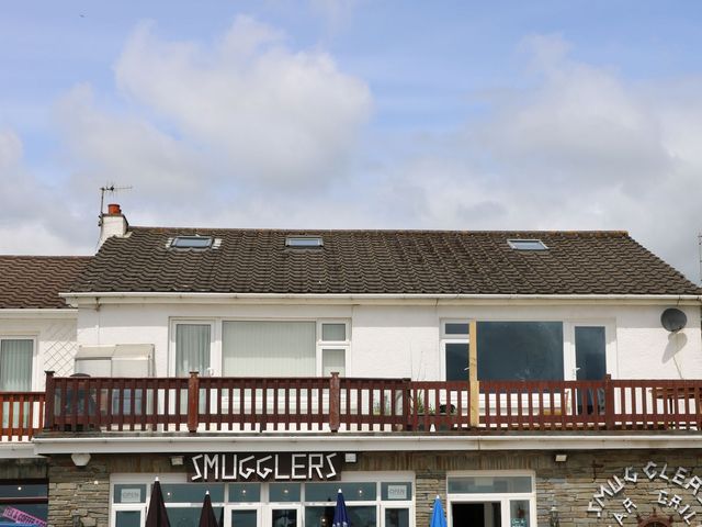 A building with a balcony and windows at The Cartwheel in Amroth