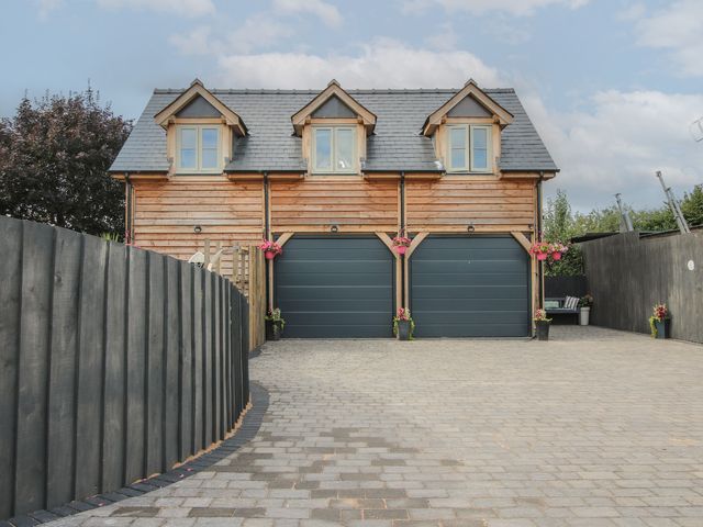 A garage with wooden exterior and driveway at Little Acre in Leominster