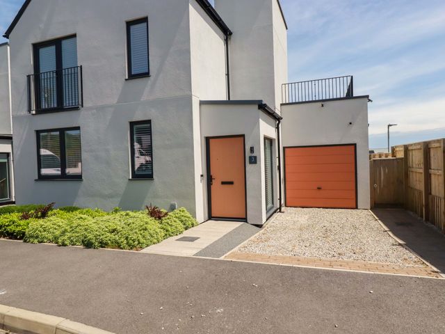 A house with a garage and pathway at Edens in Penwithick