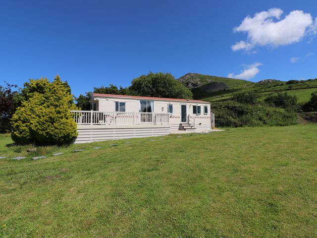 A trailer with deck in a grassy area at Mor a Mynydd in Pwllheli