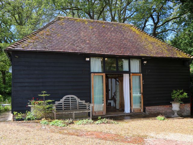 A building with a bench and open doors at Petworth Barn in Petworth