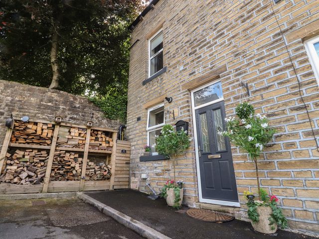 An entryway with wood storage and planters at 10 Oak Street Keighley