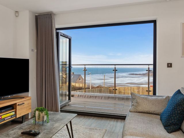 A living room with a view of the sea at One Sand Banks in Haverfordwest