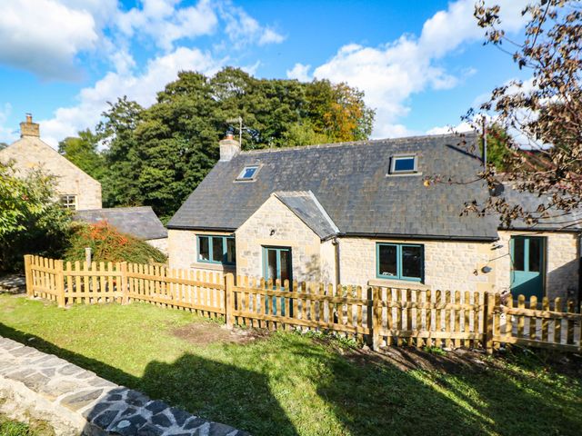 A house with a fenced garden at Stone Lily Cottage
