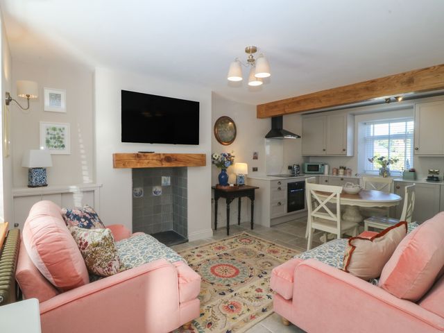 A living room with a kitchen area at Foxglove Cottage in Conwy