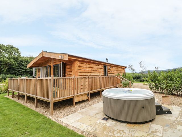 A log cabin with a hot tub and decking at Mallard in Ross-on-Wye