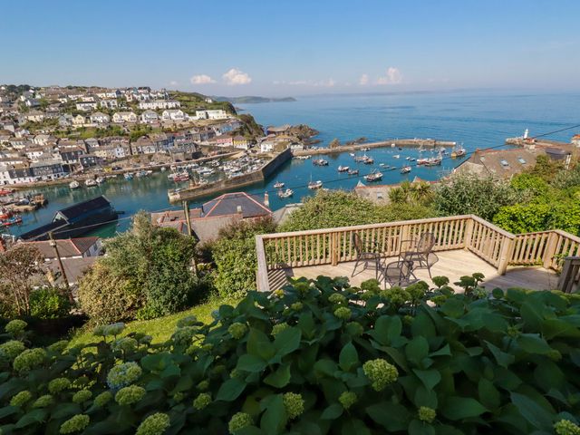 An outdoor area with a deck overlooking a harbor at Trewollock in Mevagissey