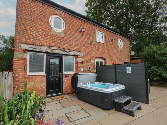 An outdoor area with a hot tub and patio at Barn 1 in Day Green near Rode Heath
