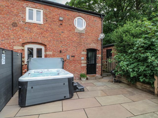 An outdoor area with a hot tub and patio at Barn 2 Day Green near Rode Heath