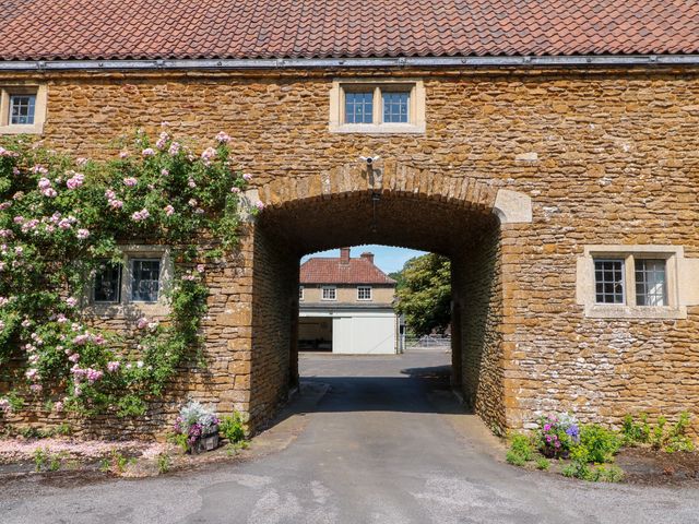 An archway with flowering plants at The Stable Flat