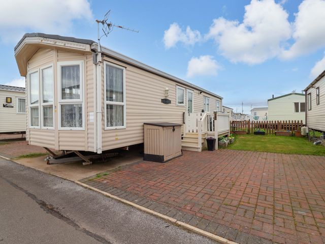 A caravan with steps and a fenced garden at Winchester - 478 Abergele